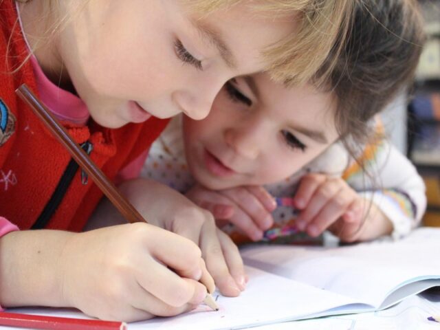 Photo of two children writing