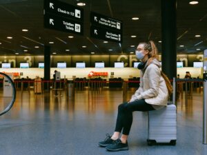 Photo of woman in mask sitting in airport