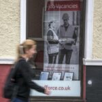 woman walking past job centre window