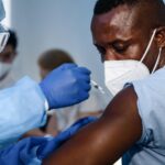 a man wearing a face mask receiving a vaccination