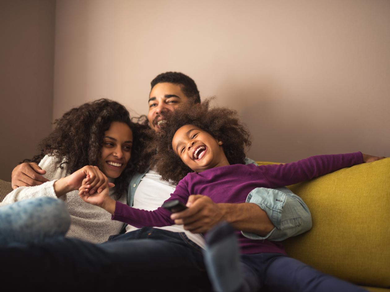 a smiling family on a sofa