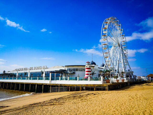 Clacton Pier, showing amusement arcade and big wheel against blue sky