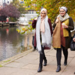 Three young Muslim women walking by a canal