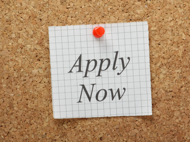 Photo of pin board with note saying apply now